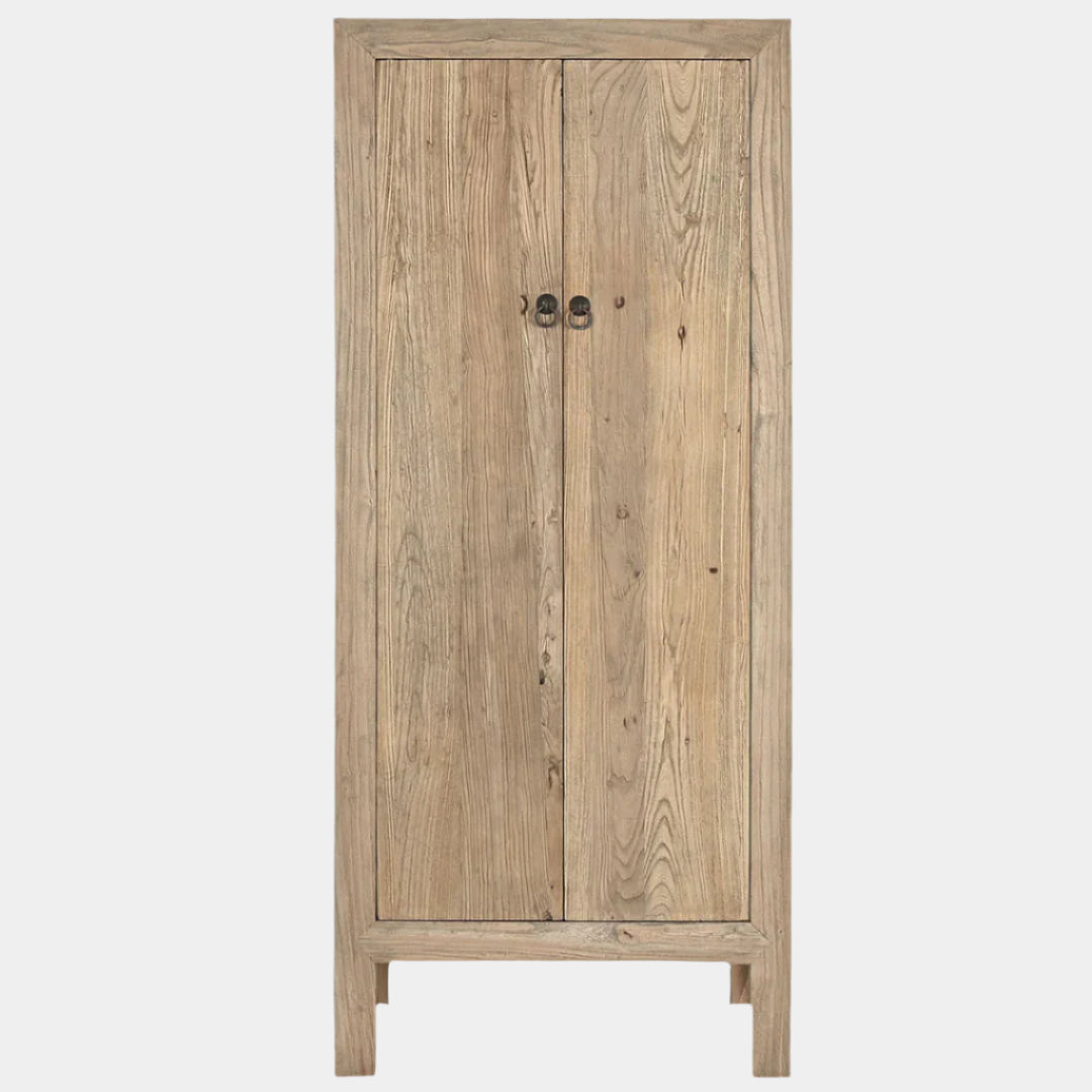 An Miro Elm Armoire made of elm wood, finished in a natural color, with two doors and a flat top, standing on a floor.