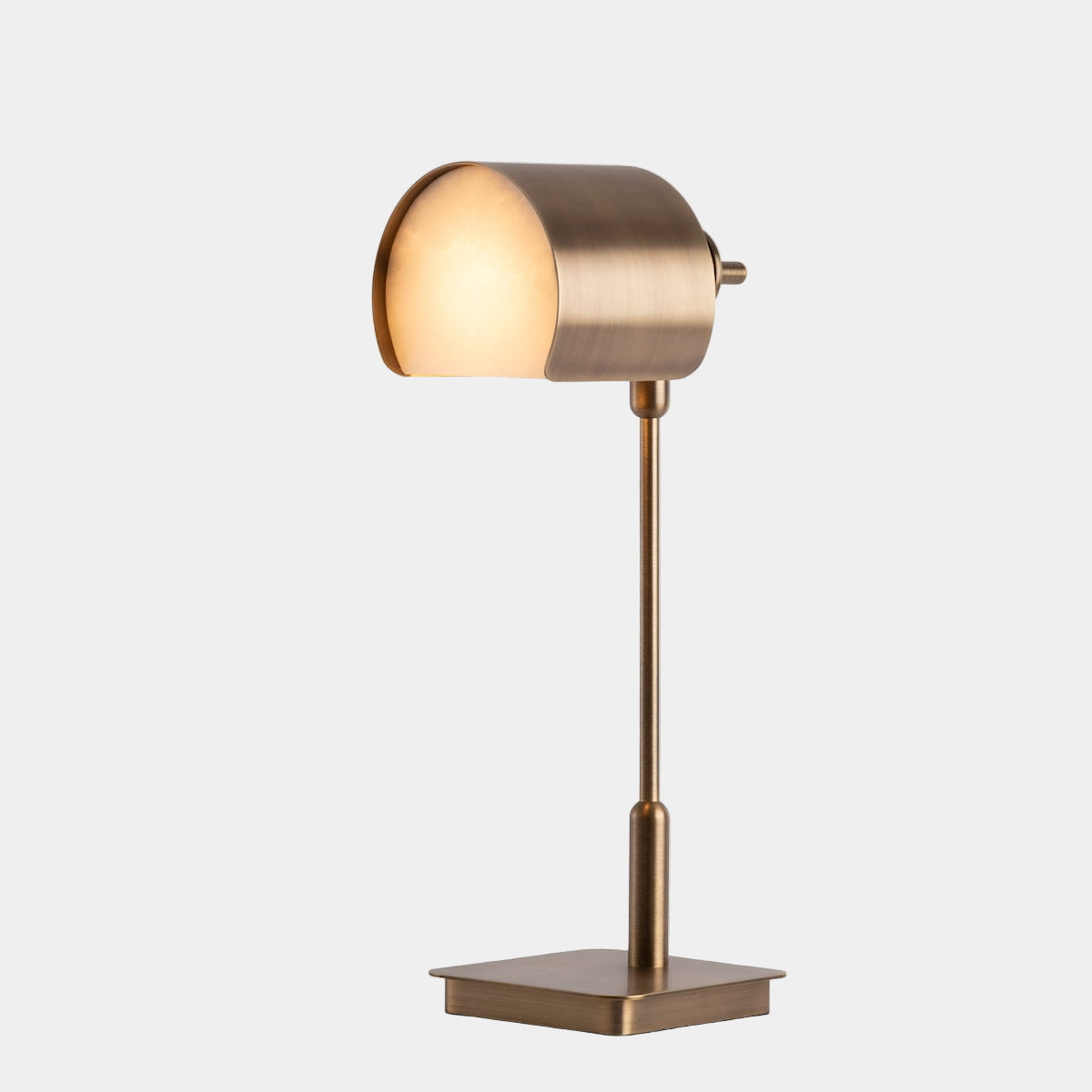 Gold table lamp with a square base on a white background