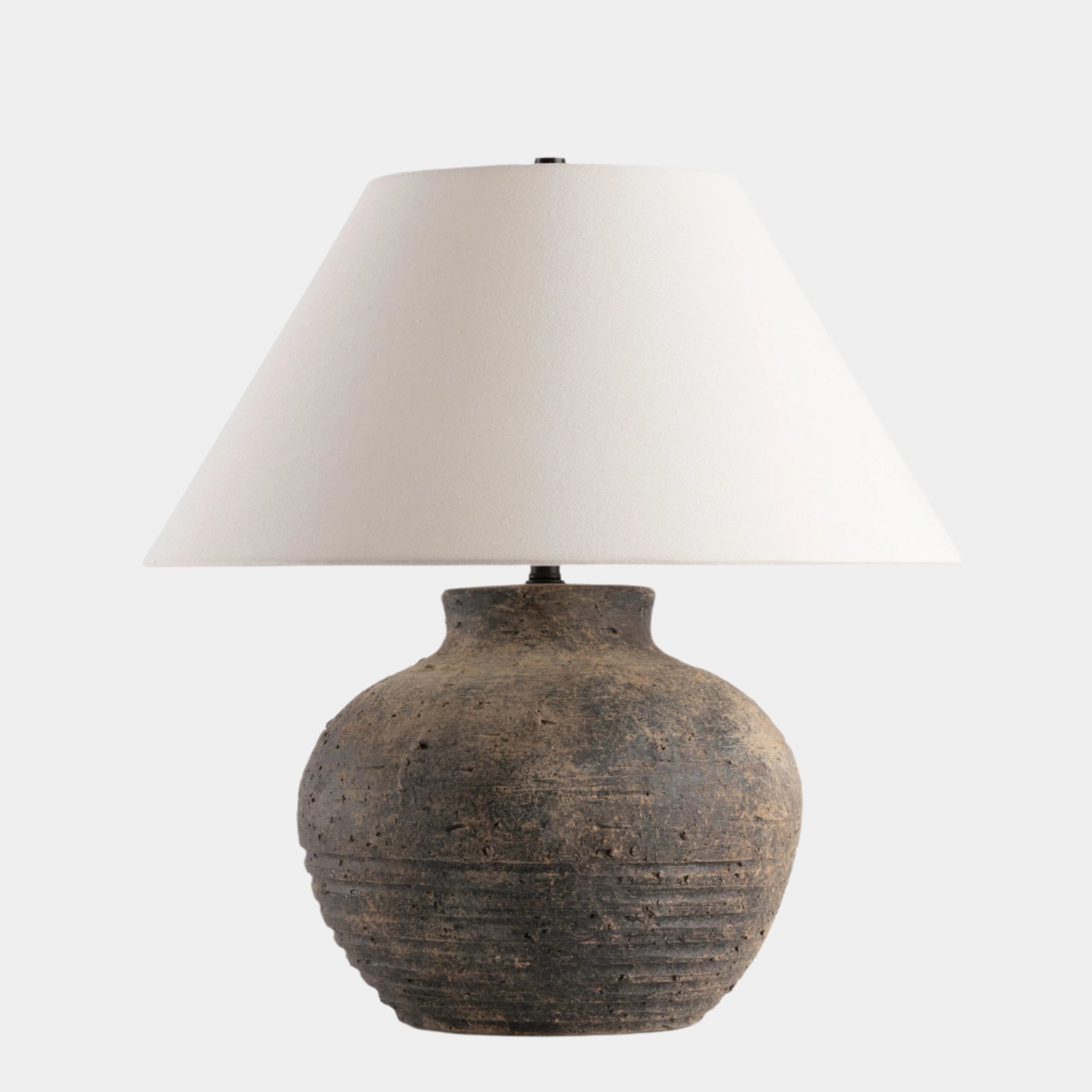 Table lamp with a textured brown base and white shade on a white background