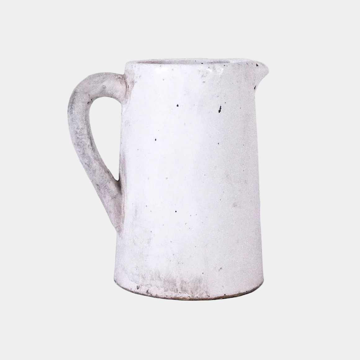 White ceramic pitcher with a textured surface on a white background