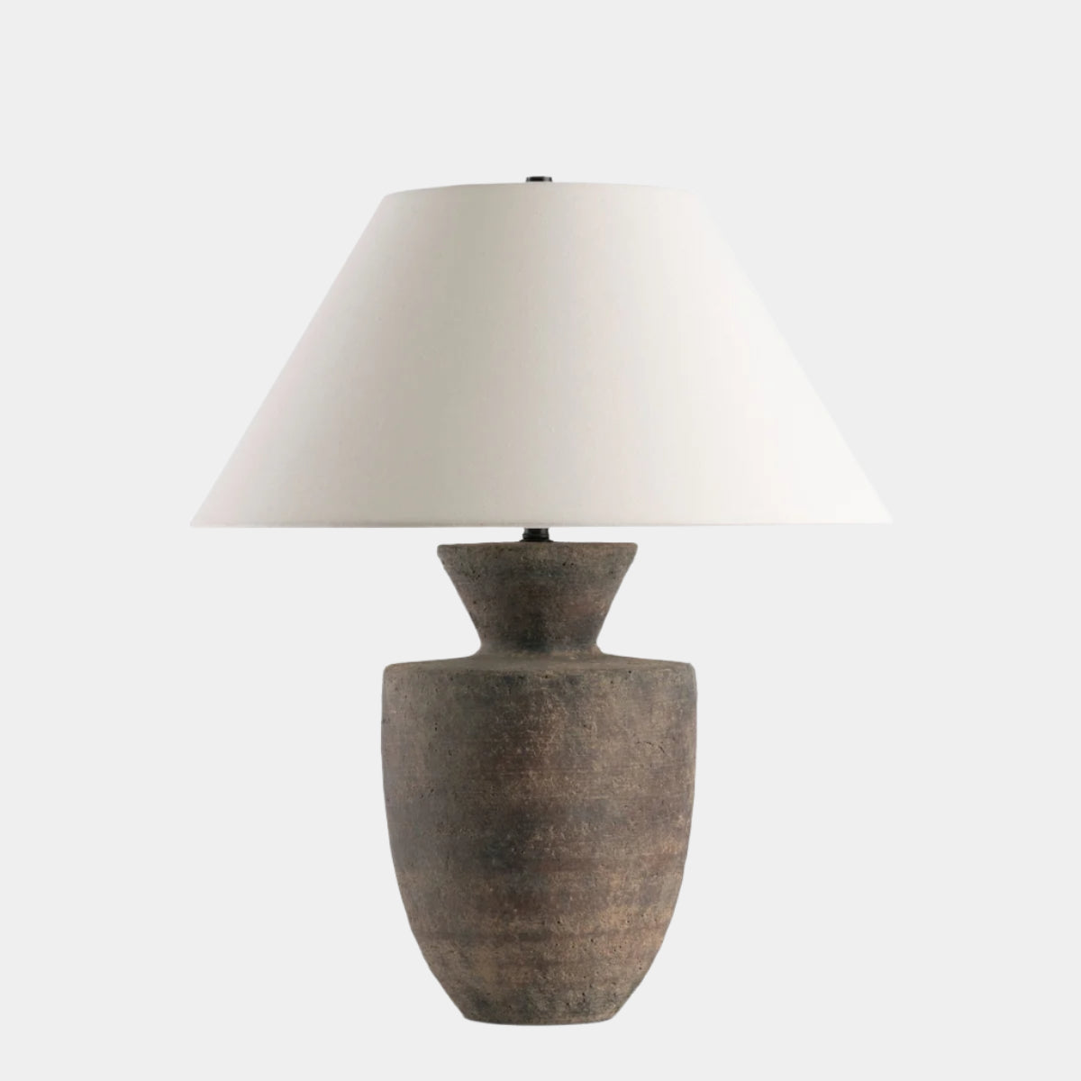 Table lamp with a textured brown base and white shade on a white background