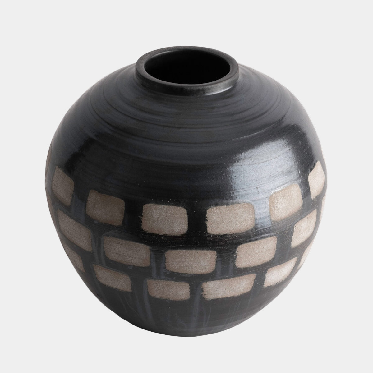 Black ceramic vase with geometric pattern on a white background